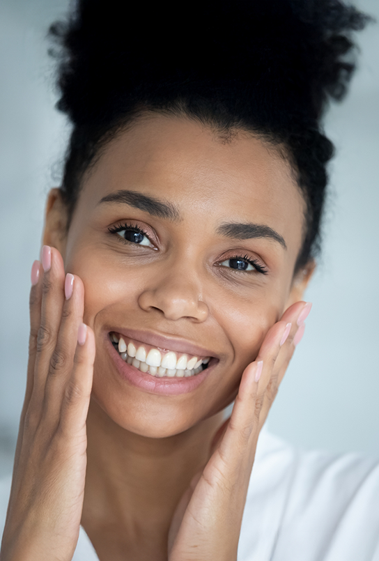 Smiling woman touching her face after BOTOX treatment in Maple Valley