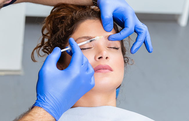Woman receiving an injection near her eyebrow