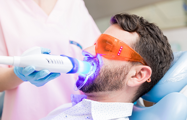 Man in the dental chair getting professional teeth whitening