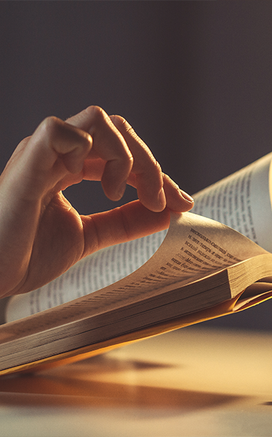 Person turning a page while reading a book