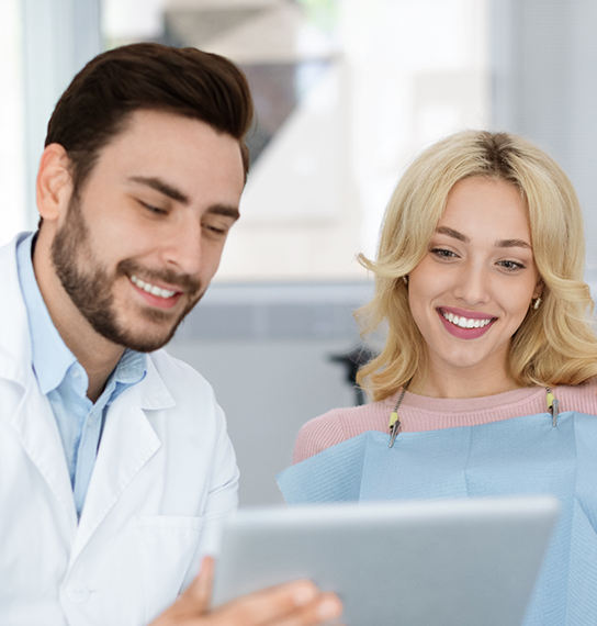 Dentist showing a tablet screen to a patient