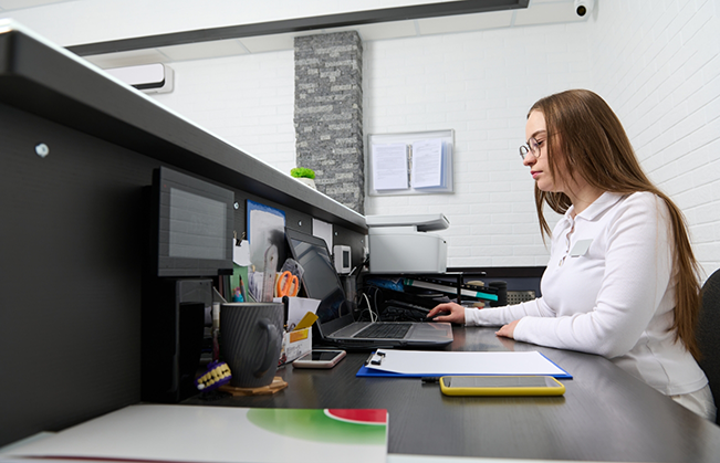 Woman typing on a computer at an office desk