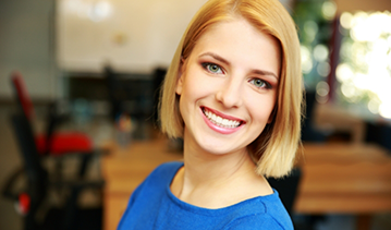 Smiling blonde woman in a blue blouse