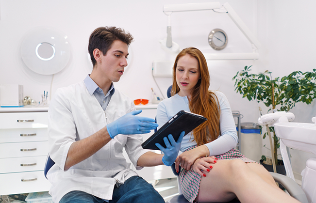 Dentist showing a tablet screen to a patient