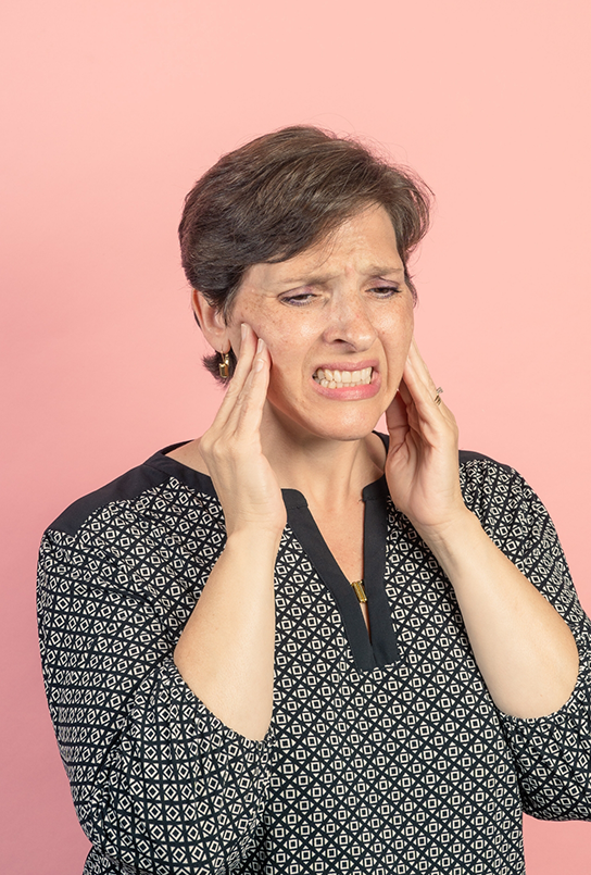 Woman holding both sides of her face in pain