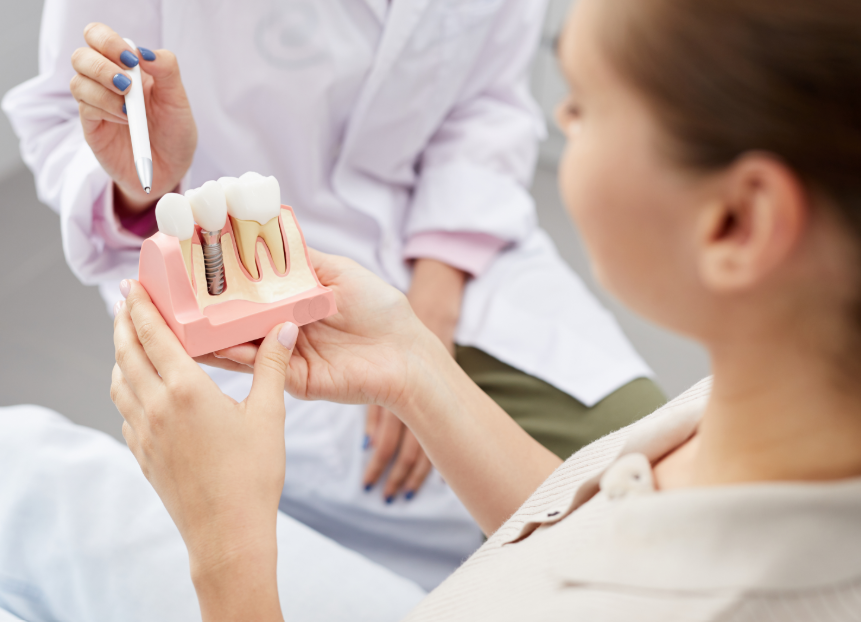 Dentist showing patient model of dental implant